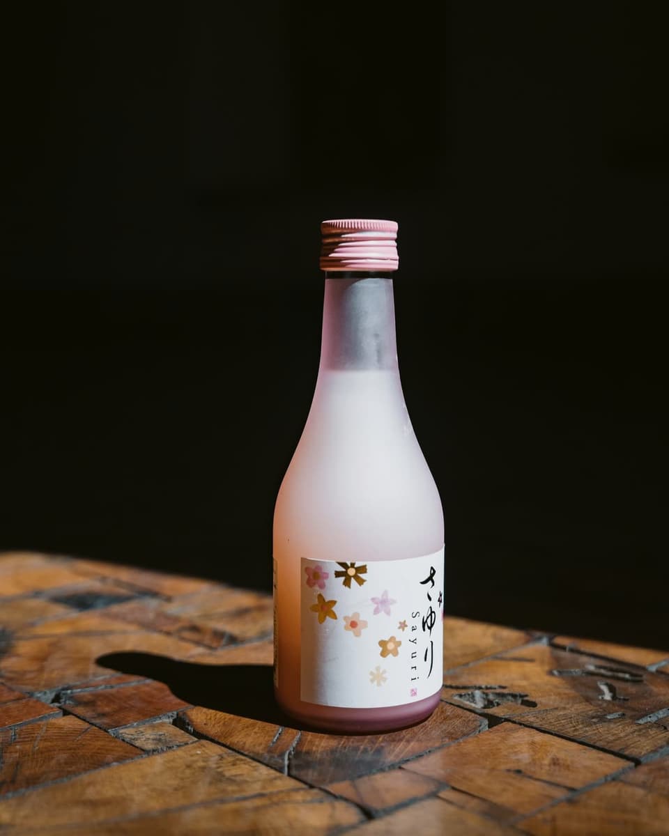 A small bottle of just-pressed sake on a wooden table