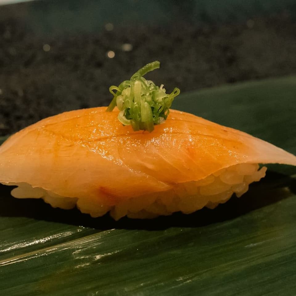 A piece of nigiri set down at the counter