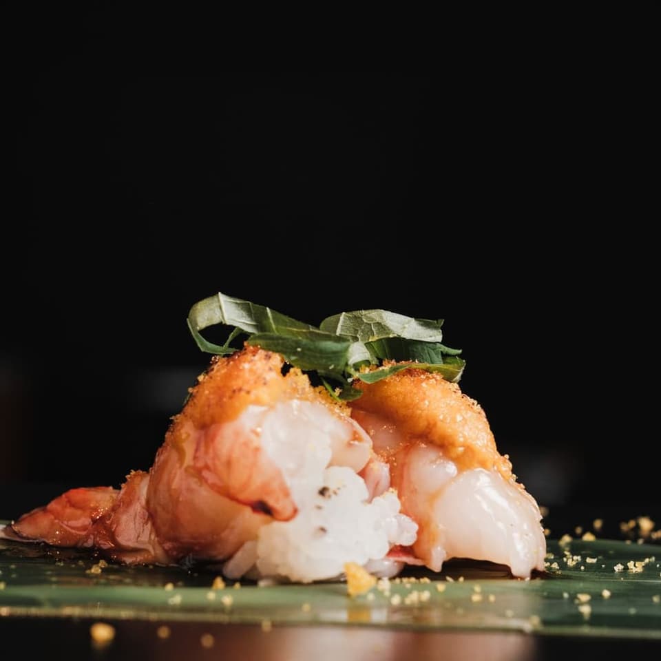 A piece of nigiri set down at the counter