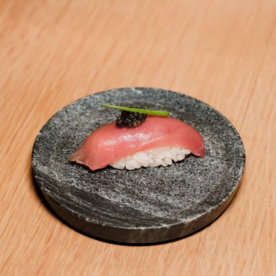 A piece of nigiri set down at the counter