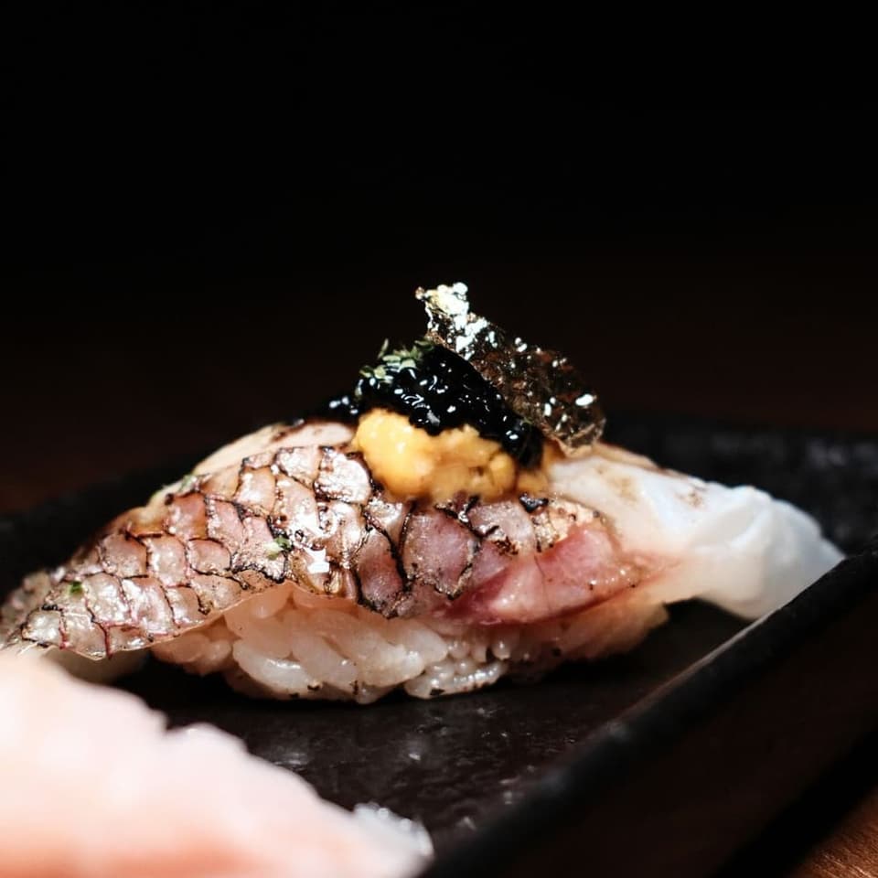 A piece of nigiri set down at the counter