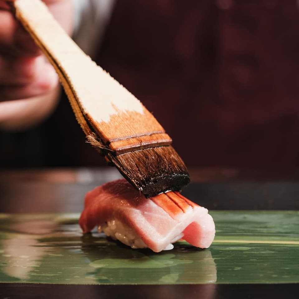 A piece of nigiri set down at the counter