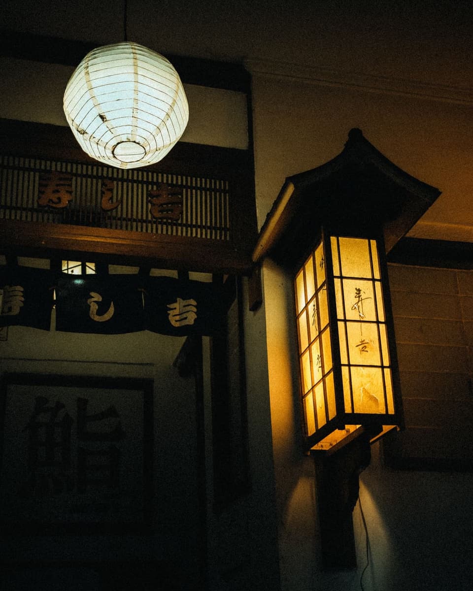 A white paper lantern lit above a doorway